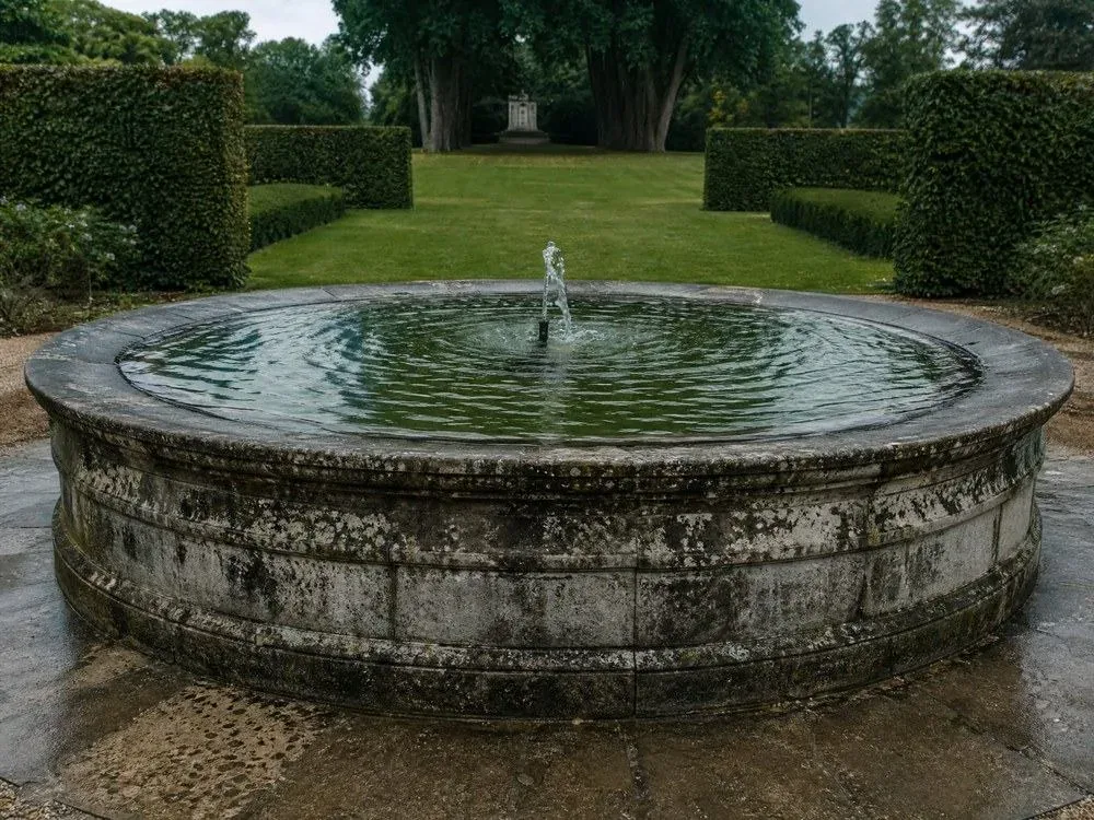 A stone fountain basin in a formal garden